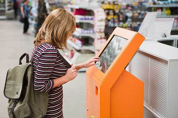 A woman using a kiosk to order product at a home improvement store.