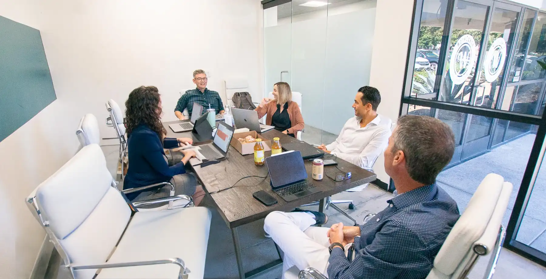 Some of the TSG team happily sitting together in a conference room.