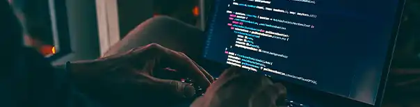 A man types code on a screen