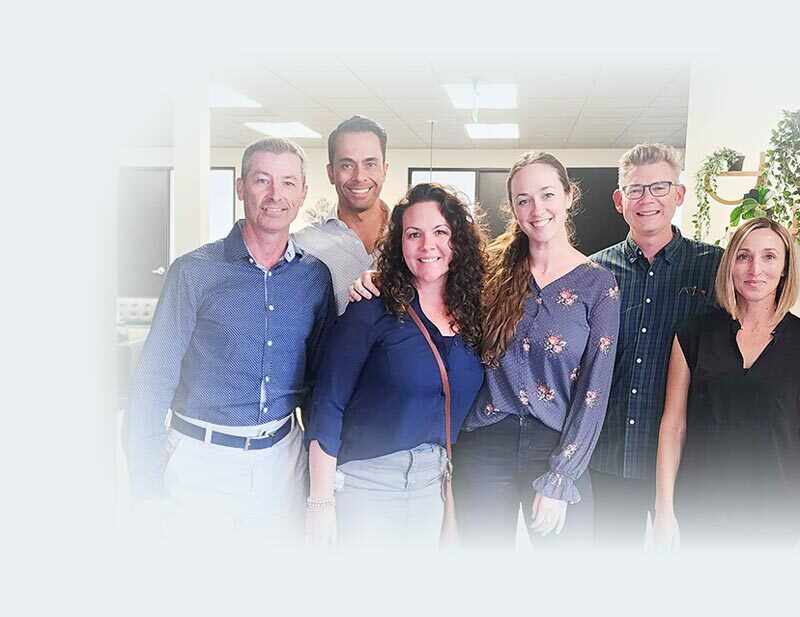 A photo of some of the TSG team outside of the conference room smiling together.