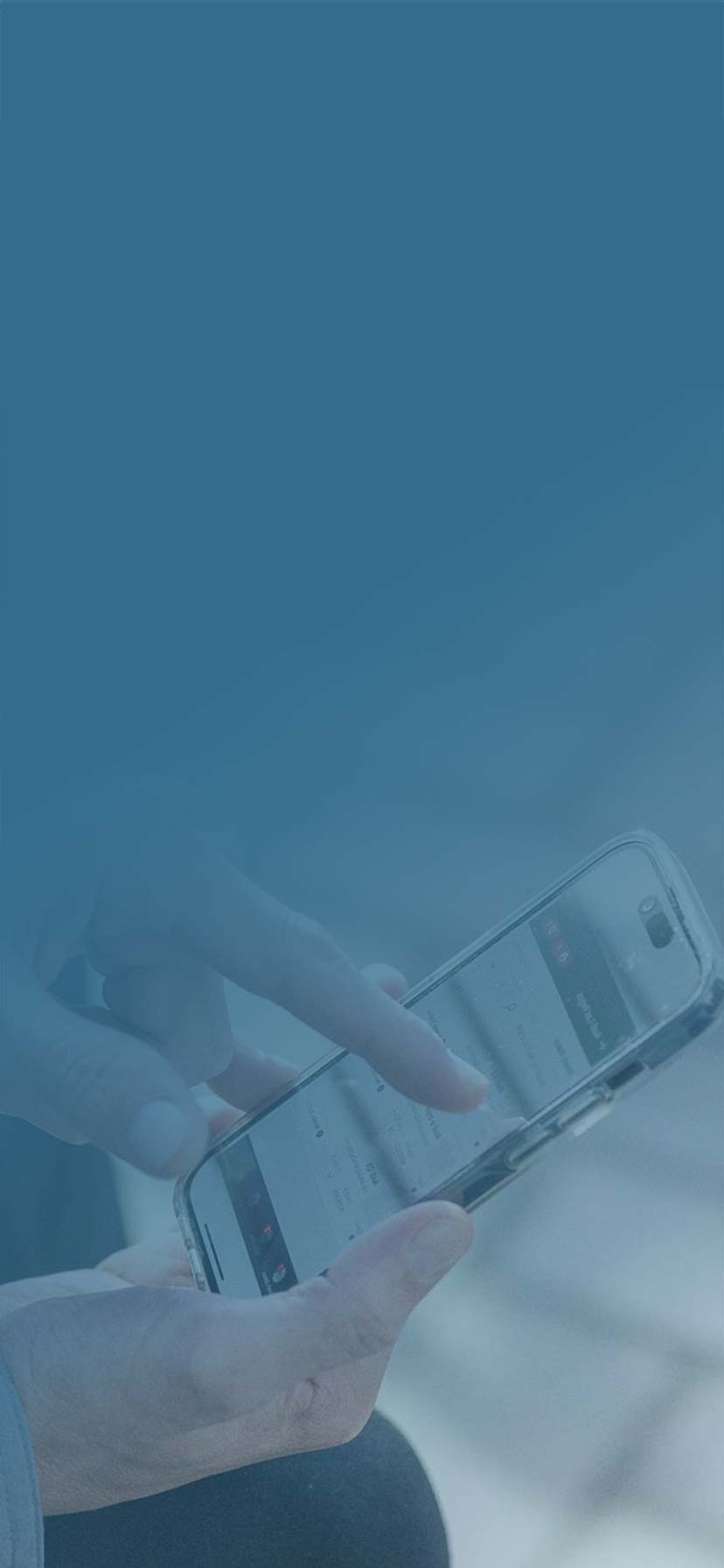 Two men reviewing a mobile app on their phone, one is pointing to a feature on the screen.