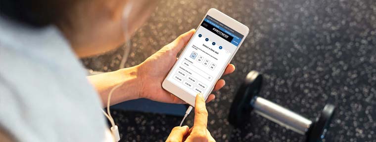 Woman at gym checking her Alaris app for the appointment she set for her child.