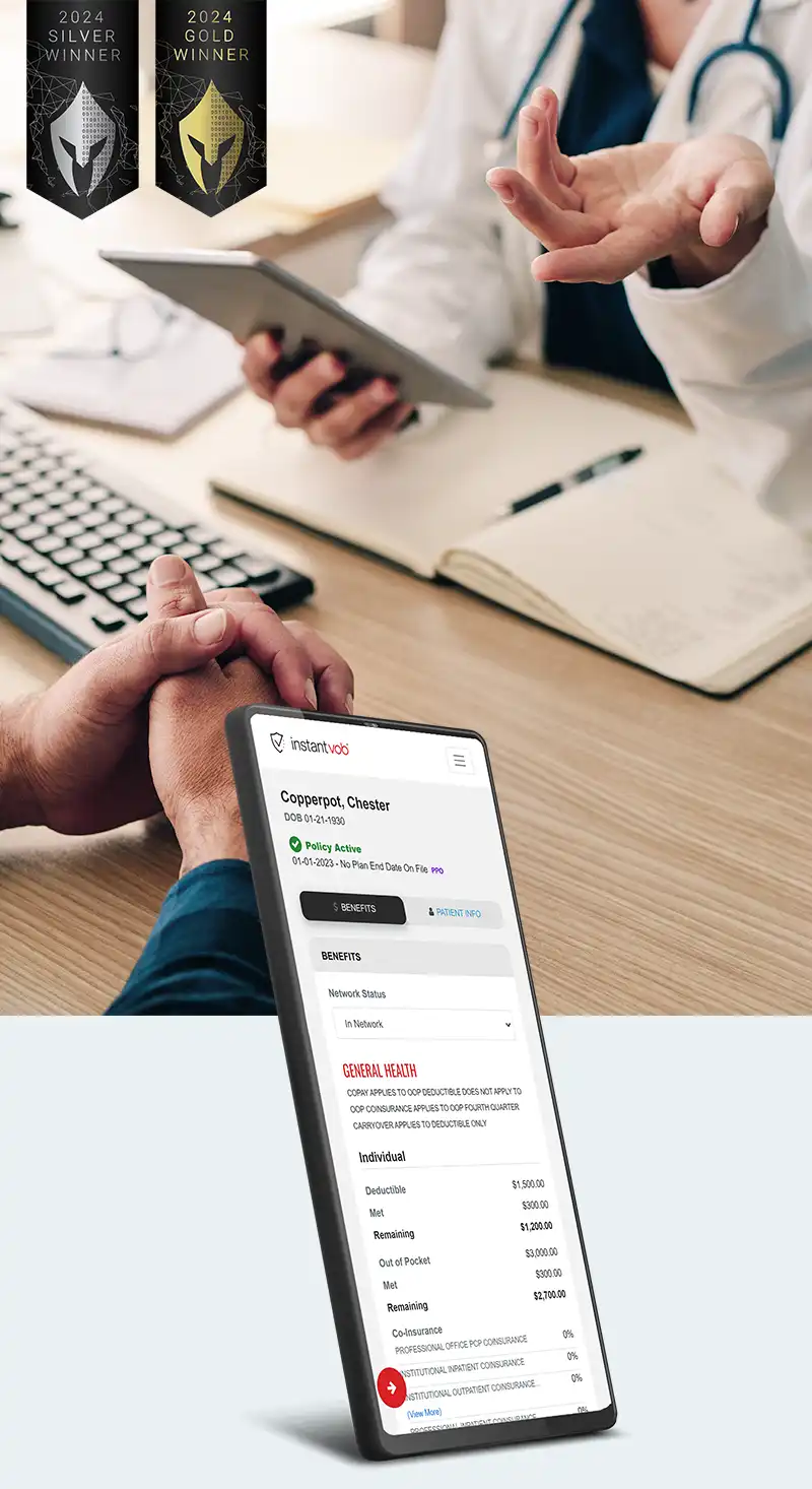 Photo of doctors hands at a desk holding a device with the patients hands folded on the other side of the desk.